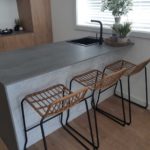 Elegant Kitchen with Wooden Chair and dark stone benchtops— Stoneworks in NSW