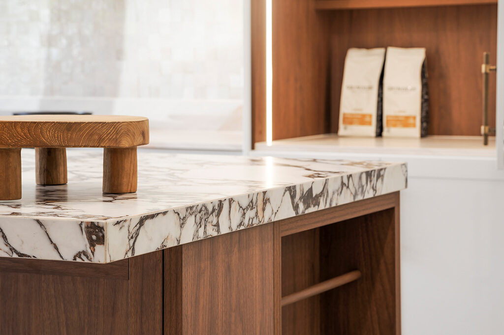 Stylish Kitchen Counter With a Polished Marble Surface and Wooden Legs — Vivid Stoneworks in Thornton, NSW