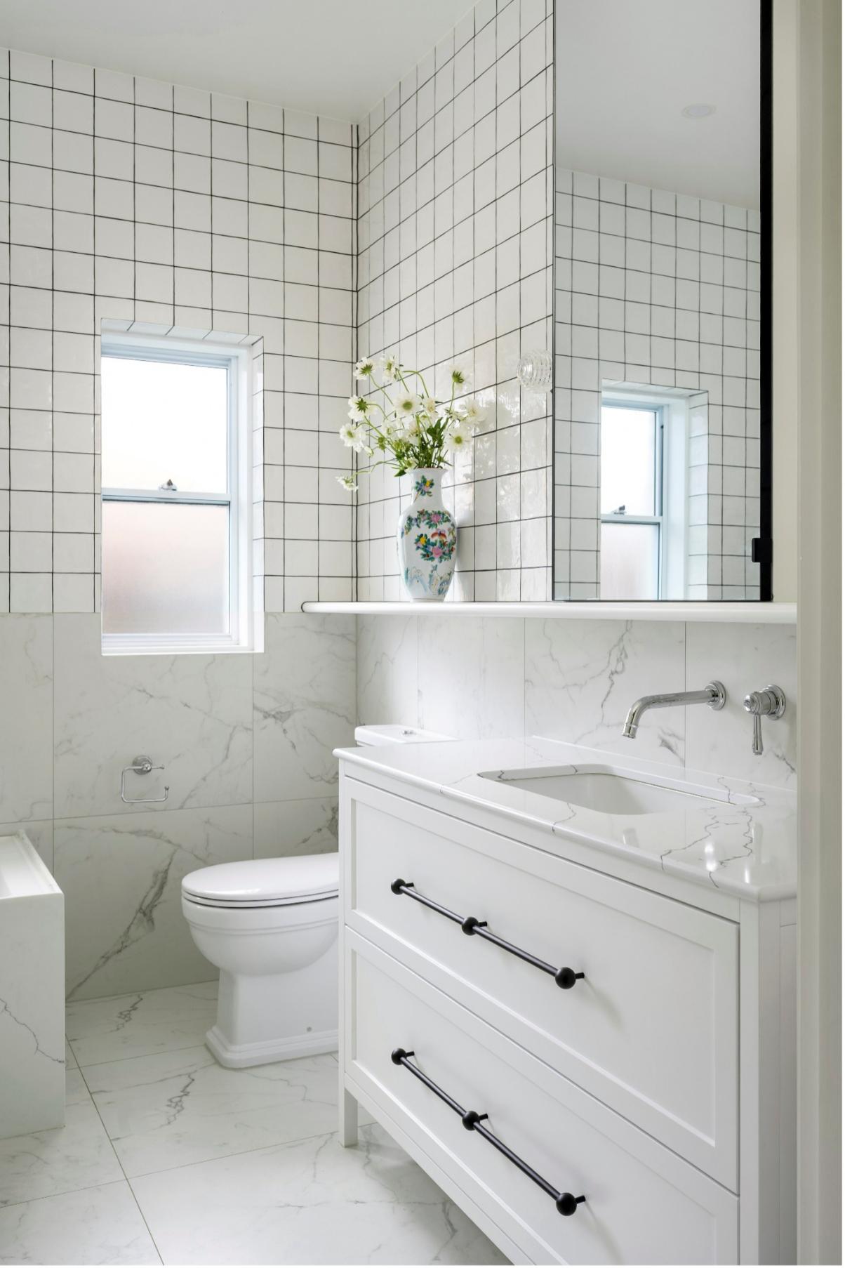 A Bright, Contemporary Bathroom Features a White Vanity with Two Drawers and Long Black Pulls — Vivid Stoneworks in Thornton, NSW